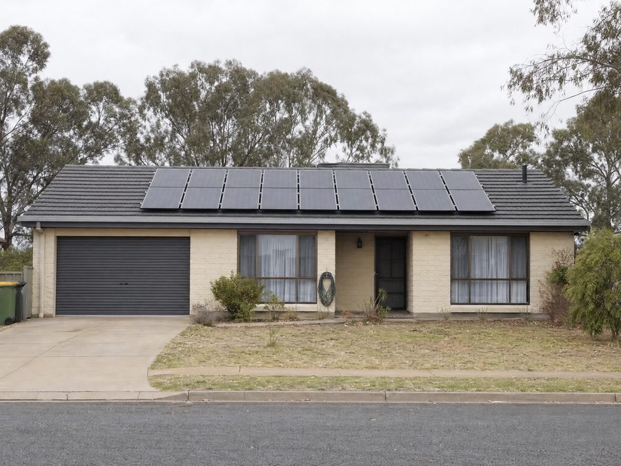 Solar panels on the tile roof of a single-storey brick veneer home